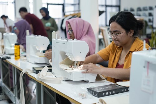 Peserta workshop sedang menjahit